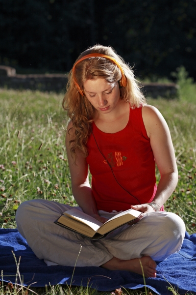 student with book and of headphones