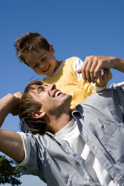 boy sitting on father s shoulders