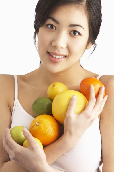 young woman holding citrus fruit in