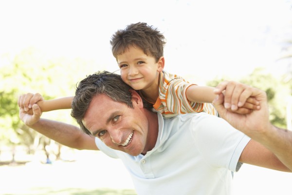 father giving son ride on back