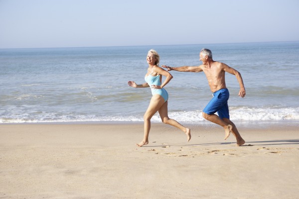 senior couple running on beach