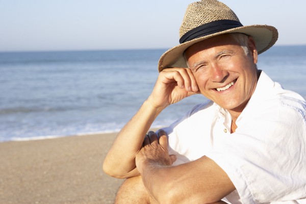 senior man sitting on beach relaxing
