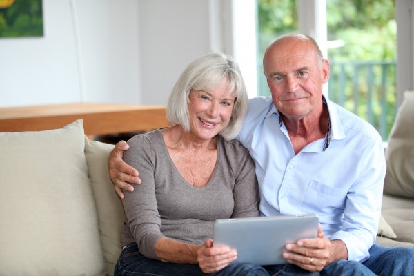 senior couple using electronic tablet at