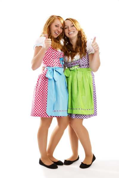 two women in dirndl show thumbs