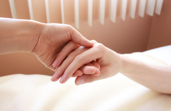 holding hand of a sick loved