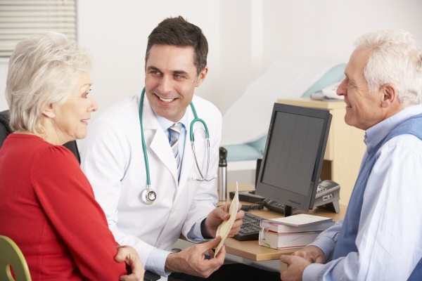 american doctor talking to senior couple