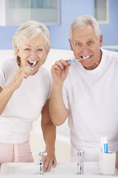 senior couple brushing teeth