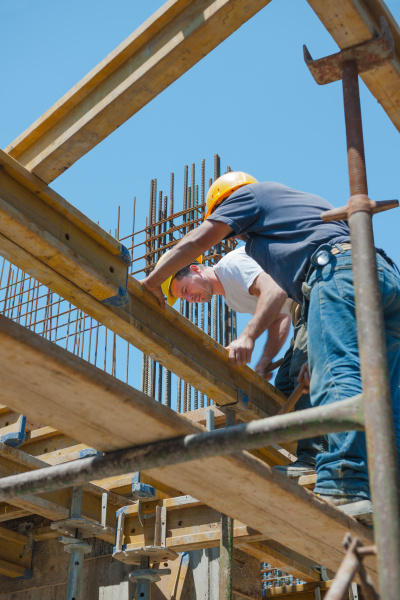 construction workers placing formwork beams