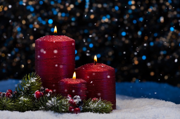three red candles in snow