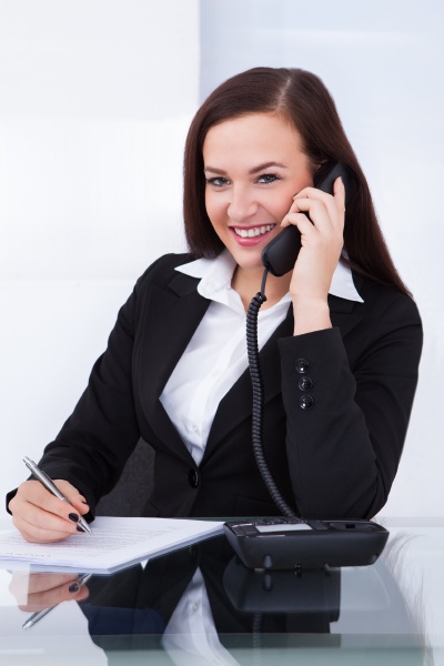 businesswoman using telephone at desk