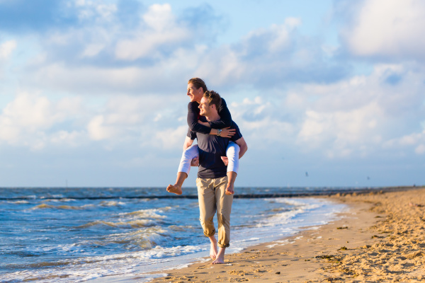 Man carries wife huckepack on beach - Royalty free image #12664566 ...