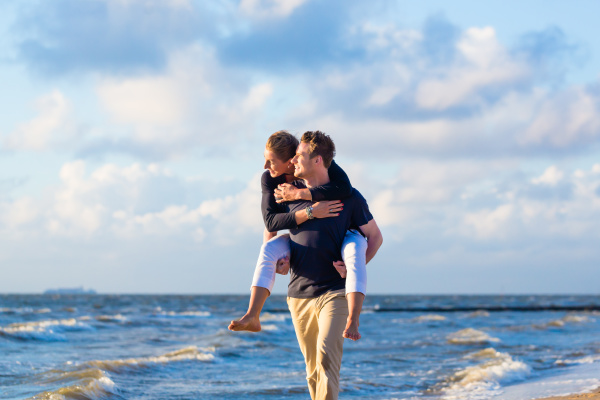 Man carries wife huckepack on be