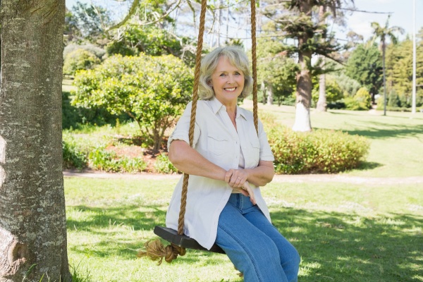 smiling mature woman sitting on swing