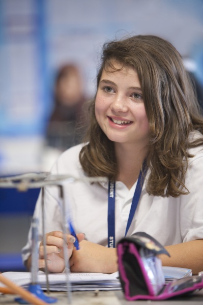 smiling girl experimenting with bunsen burner