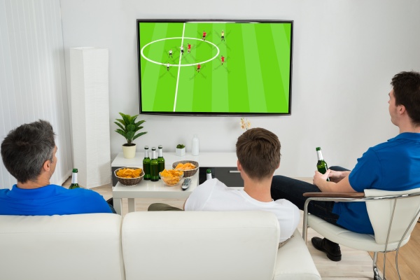 three men watching football match