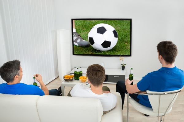 three men watching soccer match
