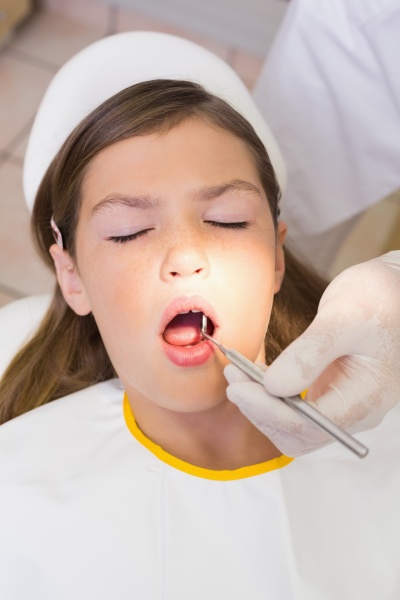 pediatric dentist examining a patients teeth