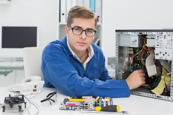 young technician working on broken computer