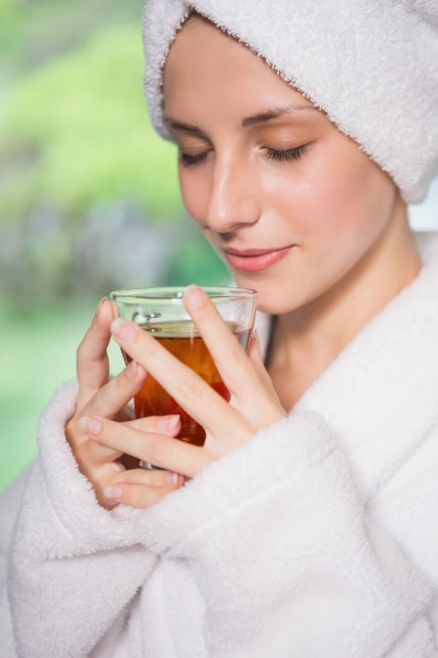 beautiful woman in bathrobe having tea