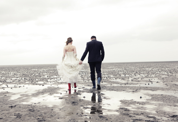 newlyweds walk in the mudflats
