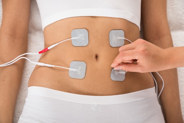 therapist placing electrodes on woman s