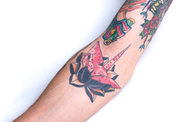 pink crane black lotus forearm tattoo