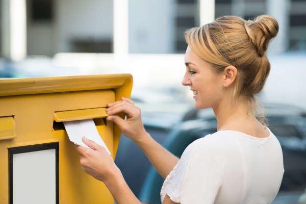 Woman Inserting Letter In Mailbox - Stock Photo #15361927