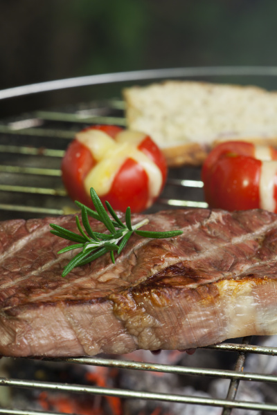 steak on the grill with tomatoes