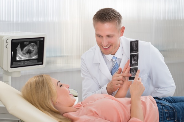 doctor explaining ultrasound scan to pregnant