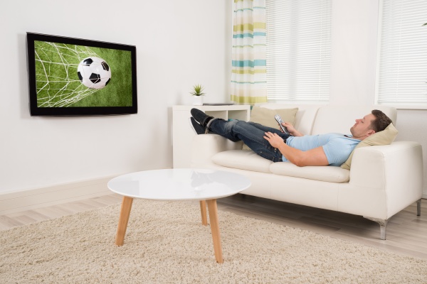 relaxed man watching football match at