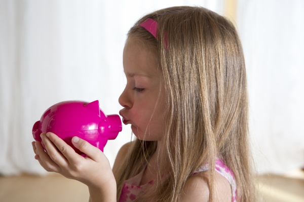 little girl kissing her pink piggy