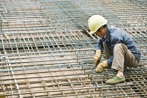 man crouching at construction site
