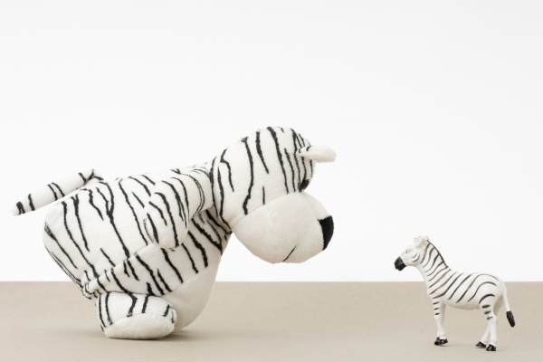 toy tiger facing toy zebra