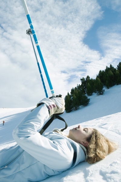 young female skier lying on ground