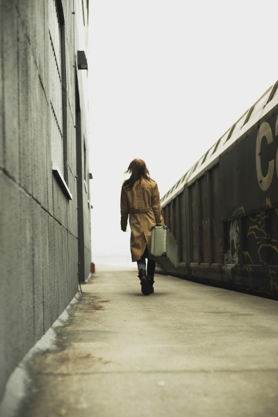 young woman with suitcase on platform