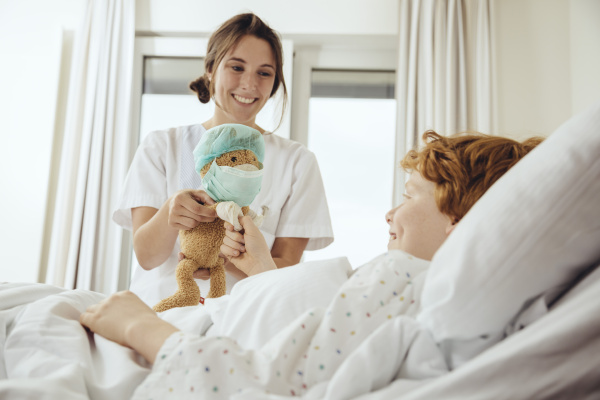 boy in hospital bed receiving toy