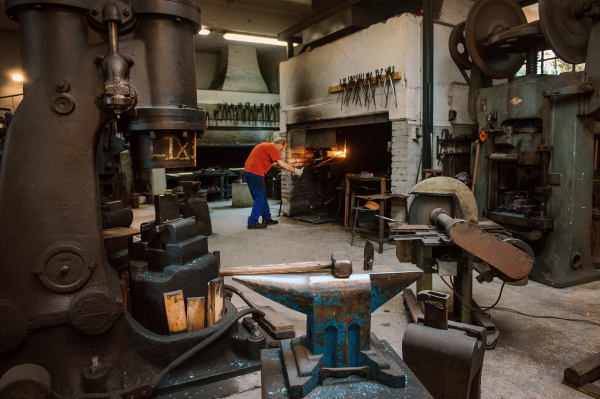 senior blacksmith working in hammer mill