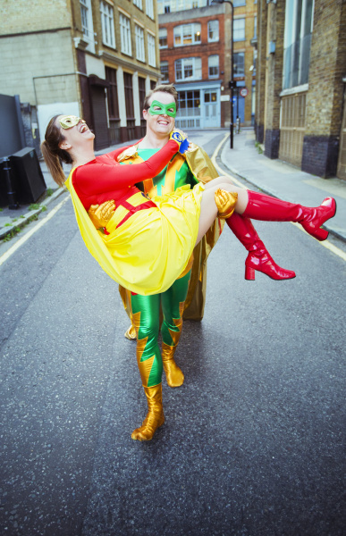 superhero carrying wife on city street