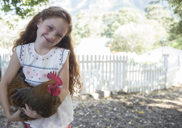 girl holding chicken at petting zoo