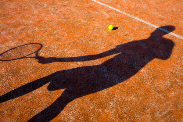 Shadow of a tennis player in action on a tennis court - Stock image ...