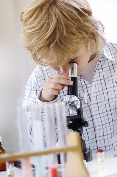 blond little boy using microscope