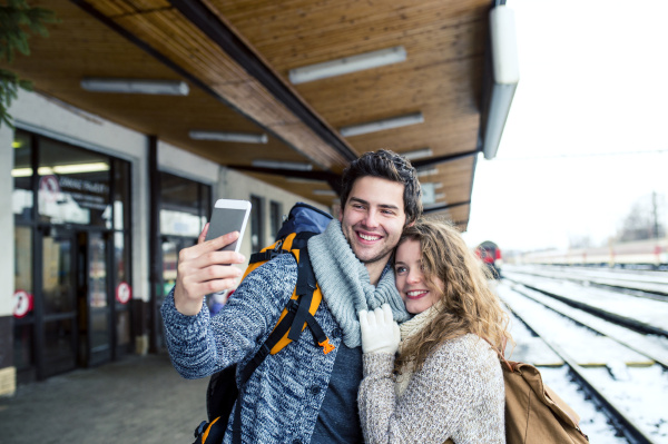 happy young couple on station platform