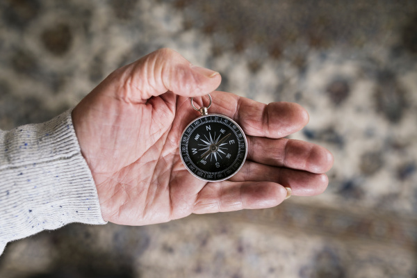 hand of senior man holding compass
