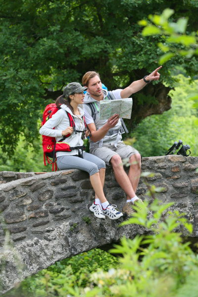 couple of hikers reading map on