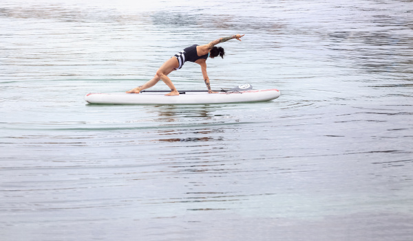 woman practicing paddle board yoga
