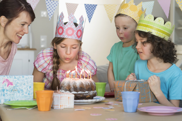 girl blowing out candles on birthday