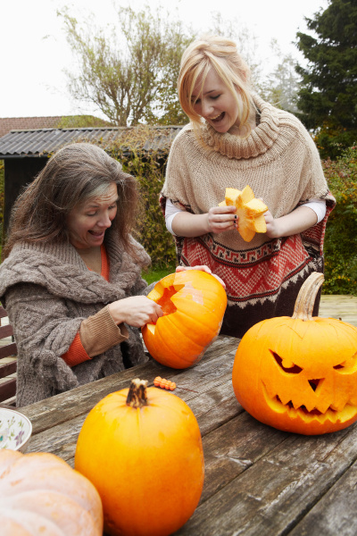 mother and daughter carving pumpkins
