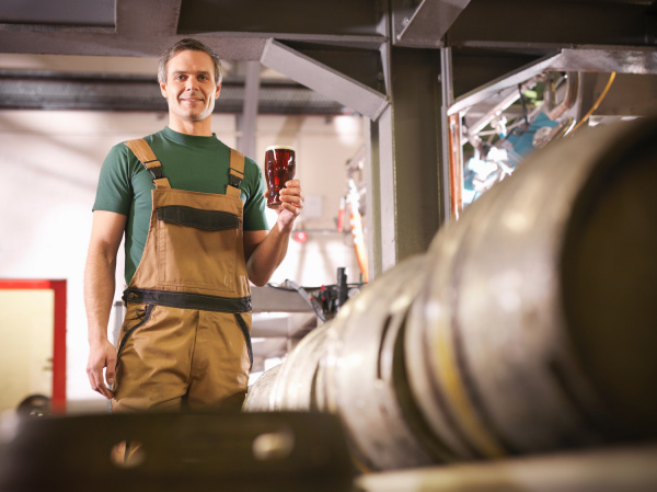 worker holding pint of beer in