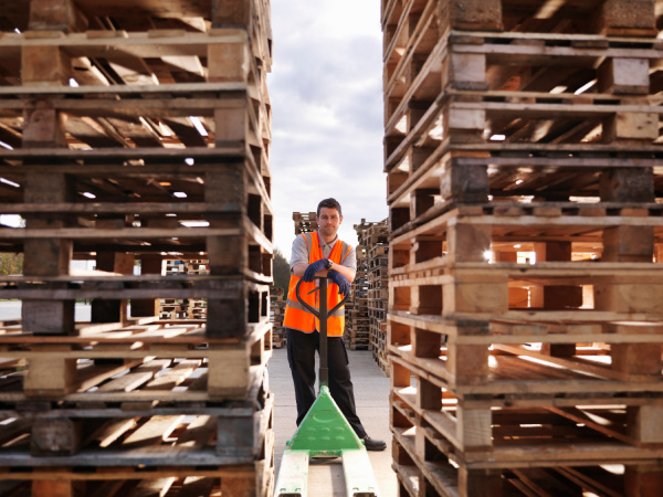 worker with pallets and pallet truck