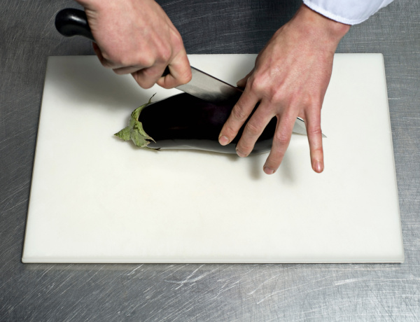 a chef cutting an aubergine